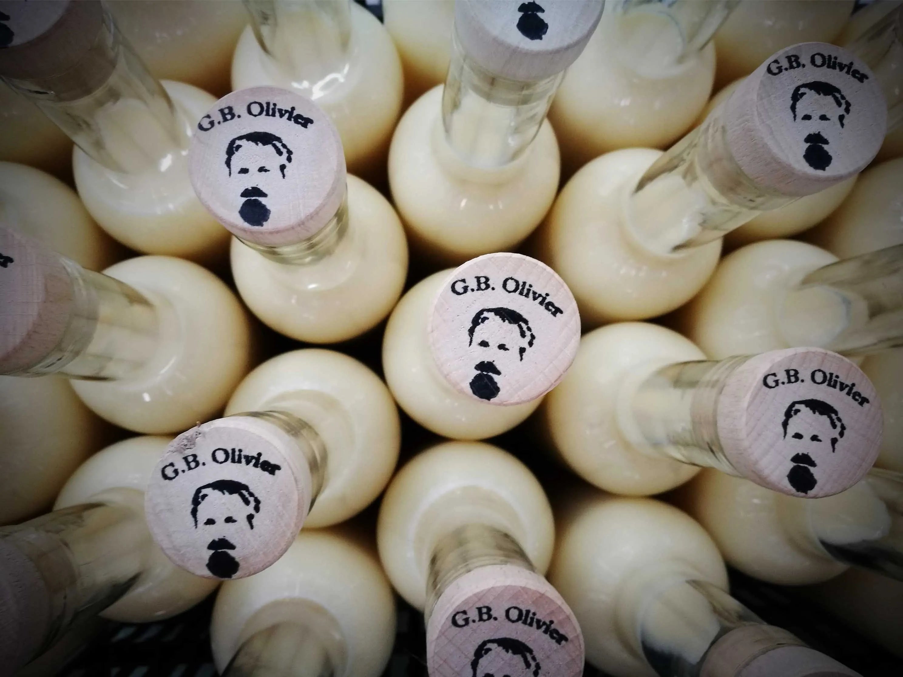 fotograf_a_art_stica_de_botellas_de_crema de limoncello_olivier_vista_alzada_de_tapones_de_mandera_con_sello_de_logo