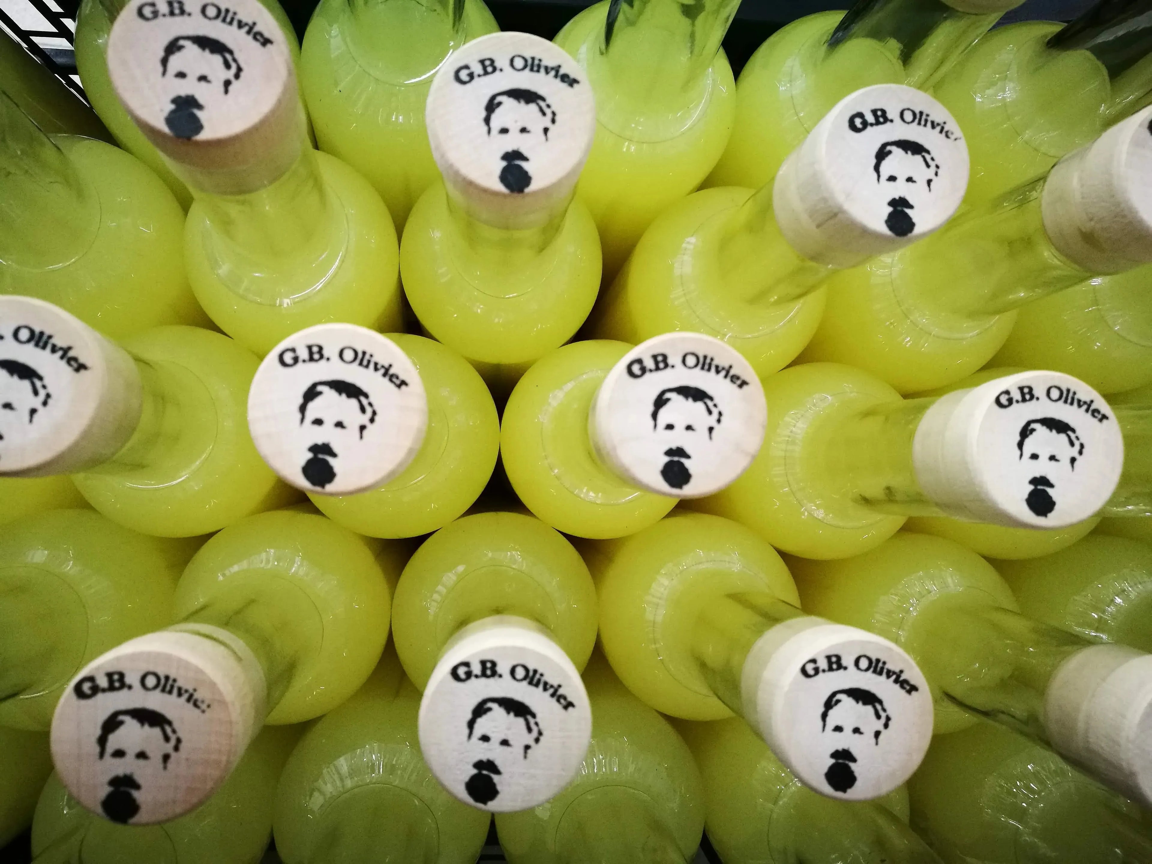 fotografia_artistica_de_botellas_de_limoncello_olivier_vista_alzada_de_tapones_de_mandera_con_sello_de_logo